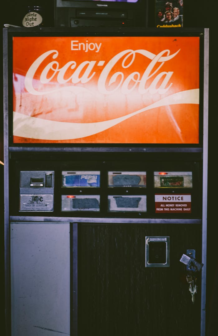 Old-fashioned Coca-Cola vending machine captured indoors with retro style.